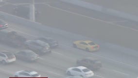 Yellow Ford mustang weaves through LA traffic