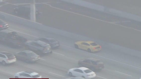 Yellow Ford mustang weaves through LA traffic