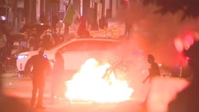 Fireworks go off, bonfire set in front of cops