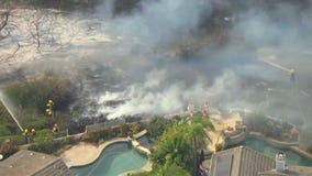 Crews fight back against fire approaching homes