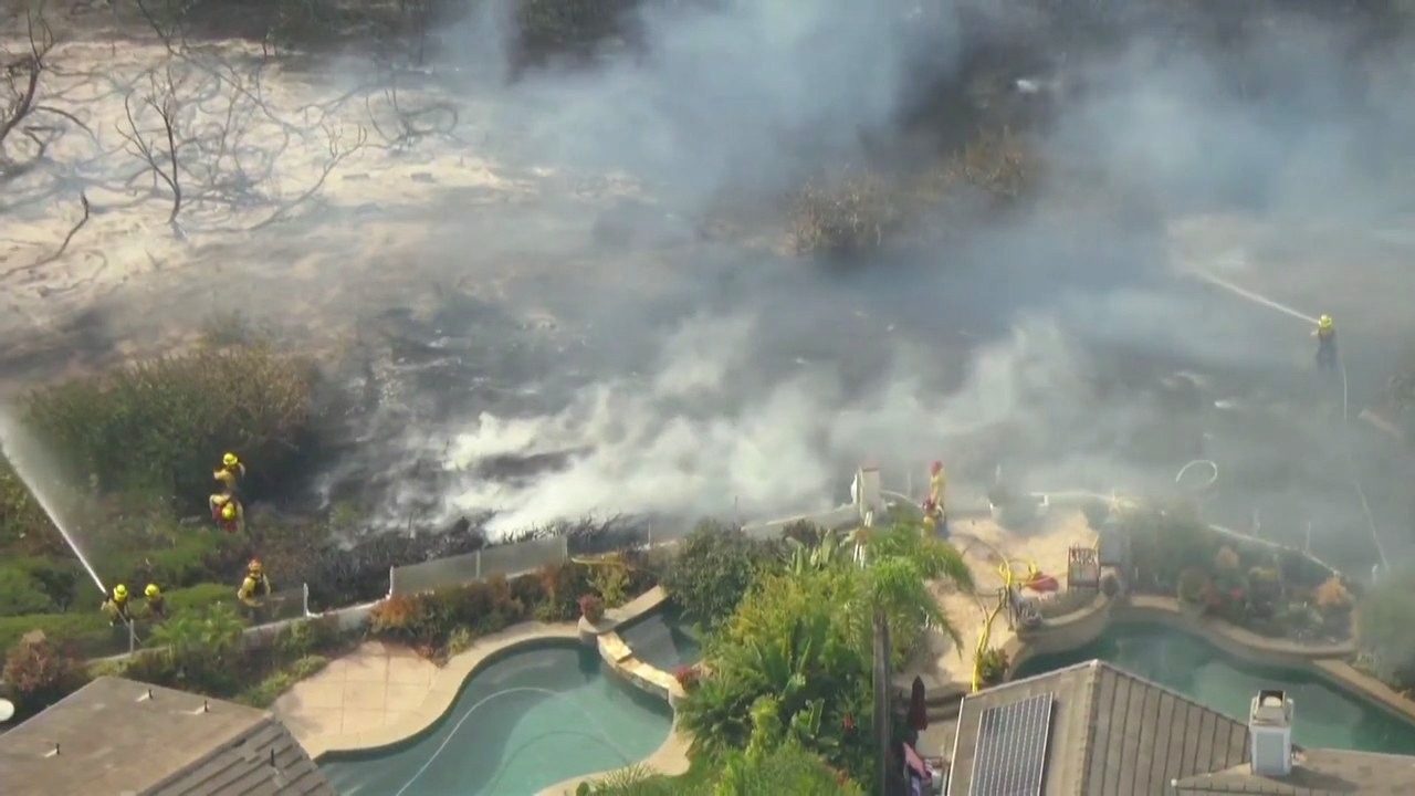 Crews fight back against fire approaching homes