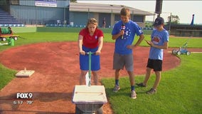 Fox 9 Meteorologist Jennifer McDermed chalks the field in Miesville