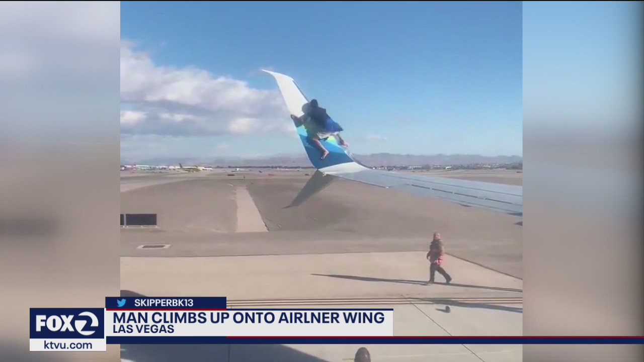 Man climbs up onto airliner wing at Las Vegas International Airport