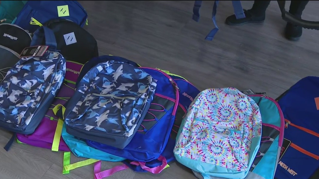 Volunteers fill backpacks to hand out to over 4K kids preparing for school