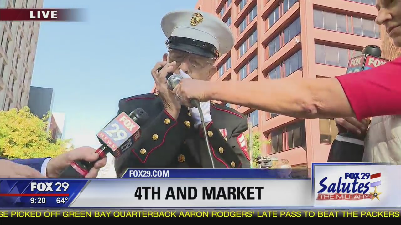 Military veteran Roland Scarinci plays America the Beautiful on harmonica