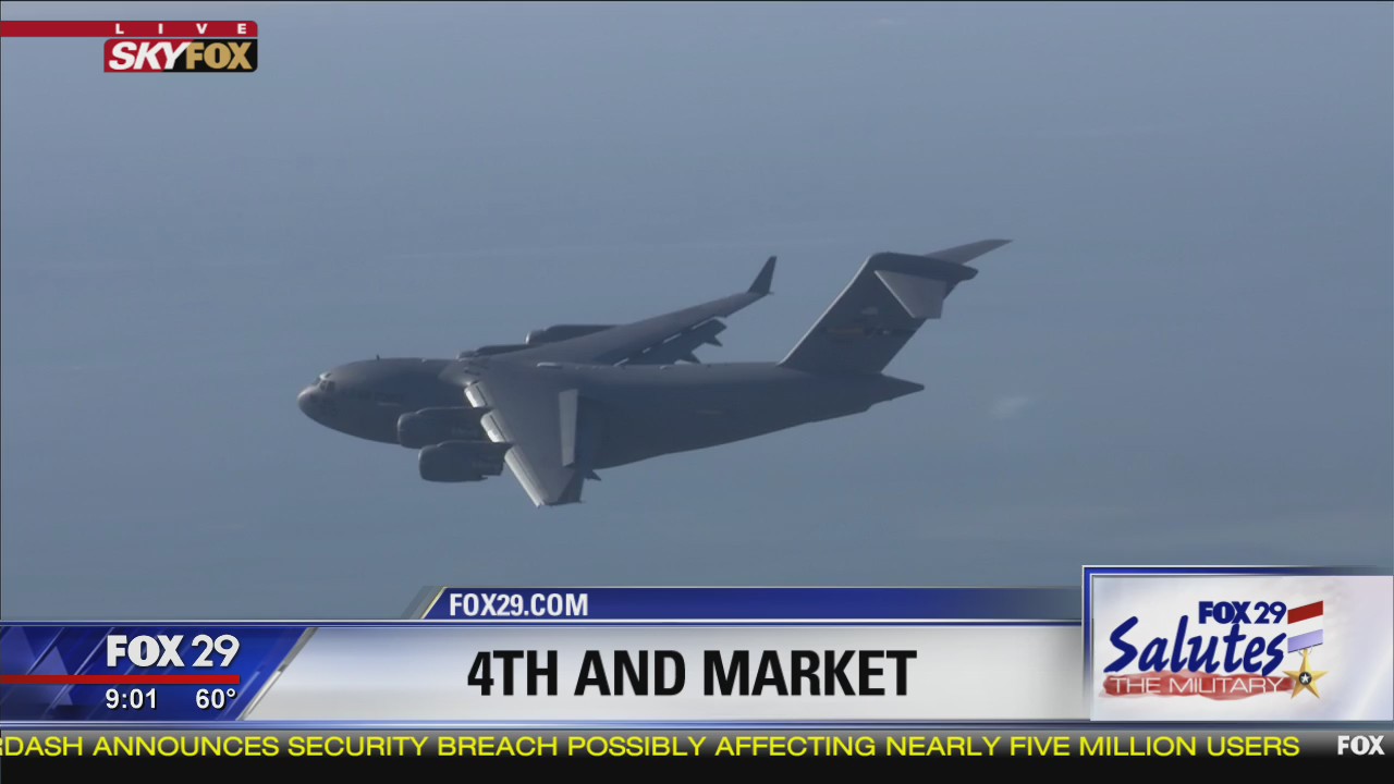 C-17 transport aircraft flies over Market Street