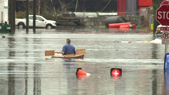 Man takes canoe for a ride through floodwater in Seattle
