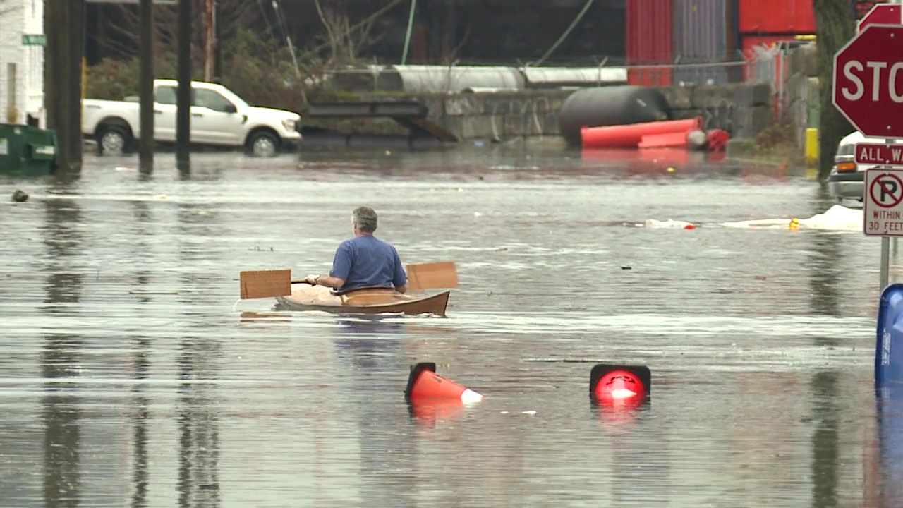Man takes canoe for a ride through floodwater in Seattle