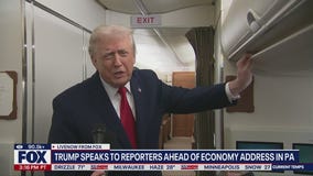 President Trump speaks to reporters aboard AF1