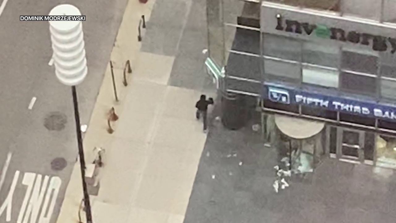 Video shows armed robbery suspect leaving Chicago bank with money in hand