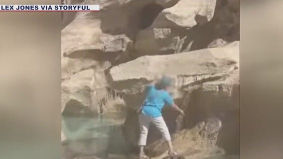 Woman wades into Trevi Fountain to fill water bottle