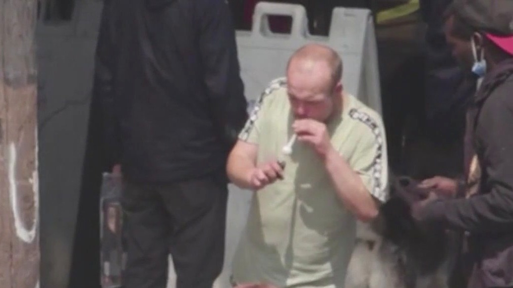 Homeless walking out of nonprofit with crack pipe