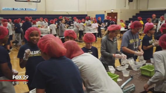 Students at Waldron Mercy Academy pack meals to feed the hungry