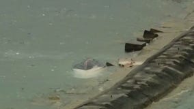 Capsized boat located on break wall amid search for missing woman