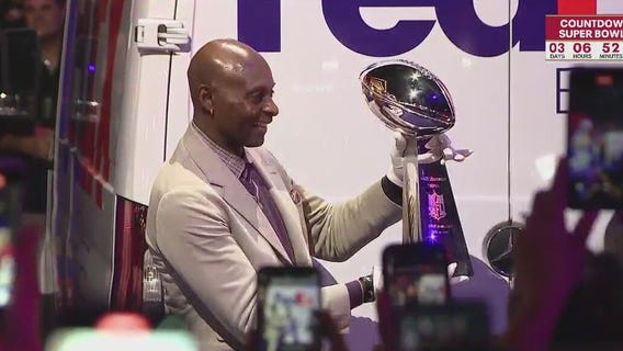 Former Niner Jerry Rice holds the silver Super Bowl trophy