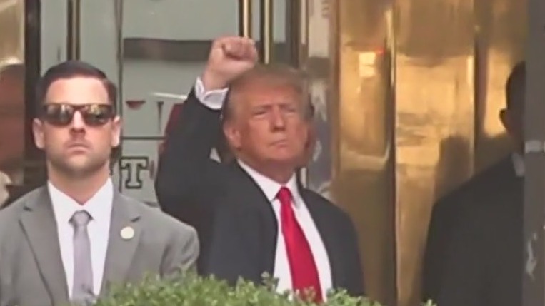 Trump waves to supporters ahead of turning himself in