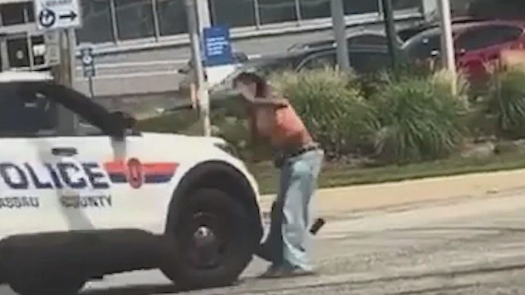 Woman waves gun at busy intersection