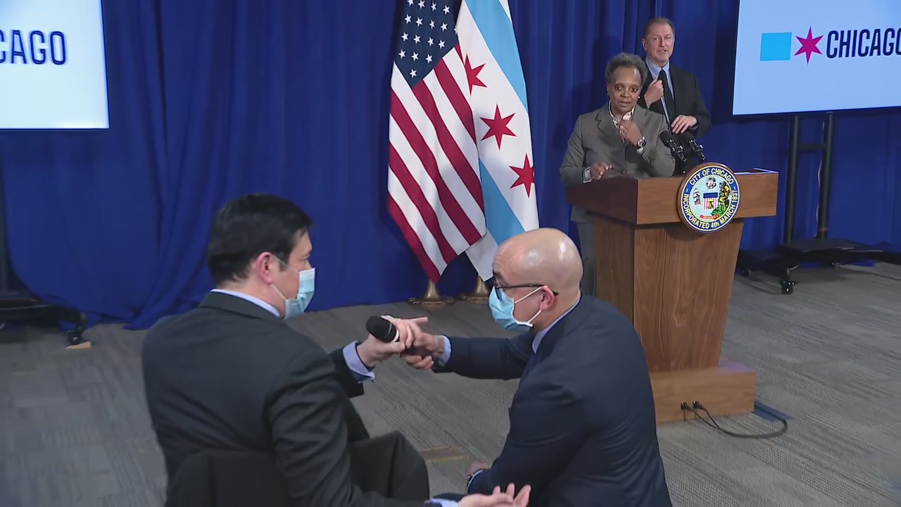 Reporter tries to grab microphone from staff member at Lightfoot news conference