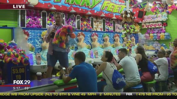 Vacationers play boardwalk water gun game at Steel Pier
