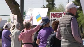 Protesters line streets outside Tesla dealership