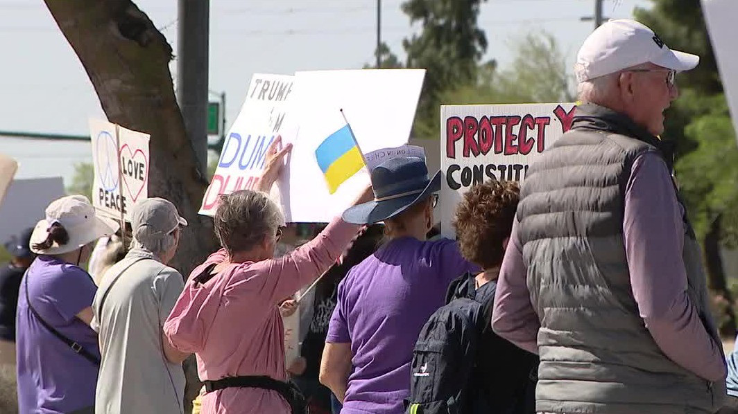 Protesters line streets outside Tesla dealership