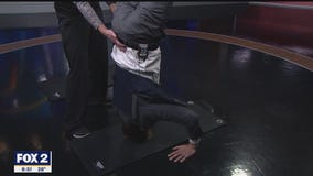 Teri Keller from the YMCA Birmingham is teaching Alan how to do a headstand