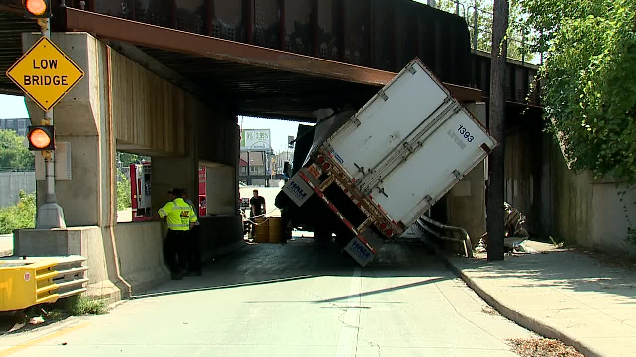 Truck stuck under bridge in Bay View
