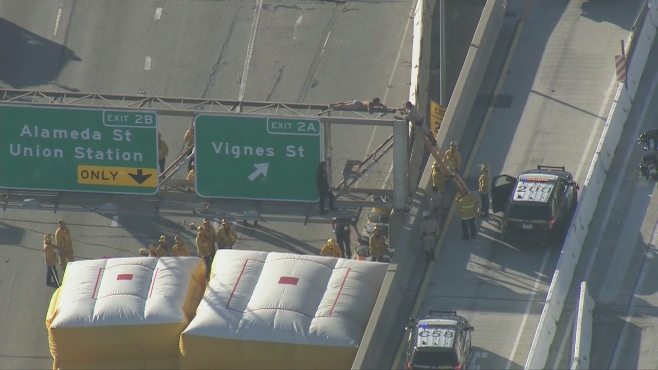 Man climbs sign of Hollywood Freeway in downtown LA