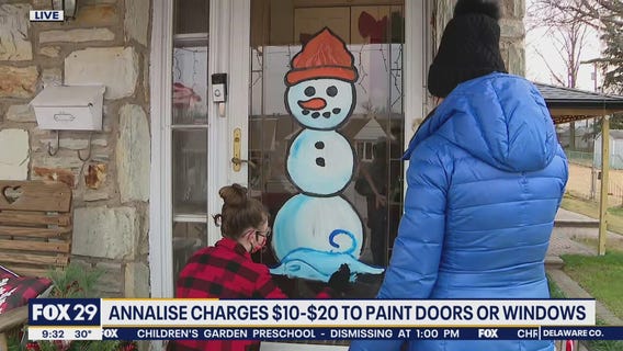 Local girl spreads cheer for the holidays by painting doors