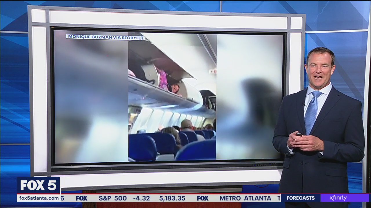 Woman gets into overhead luggage compartment