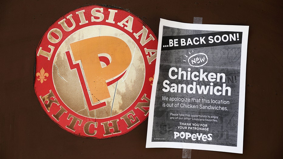 A sign indicating that chicken sandwiches are sold out hangs at a Popeyes location.