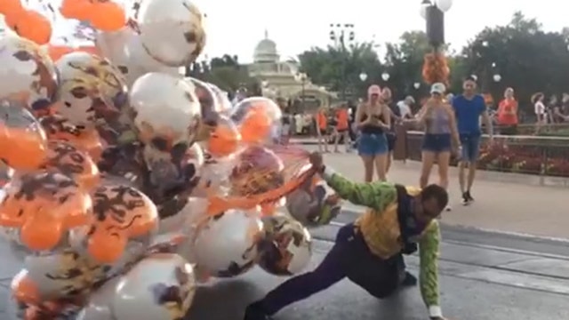Wind almost carries away balloon handler at Mickey's Not-So-Scary Halloween Party