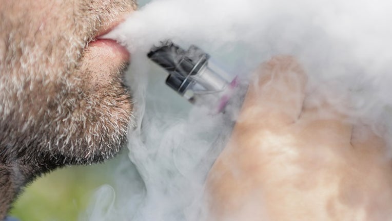 A man smokes an e-cigarette.