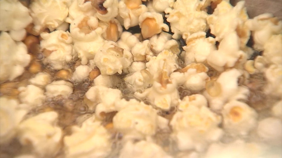 A photo showing popcorn being popped in a kettle. Photo features both popped and unpopped popcorn.