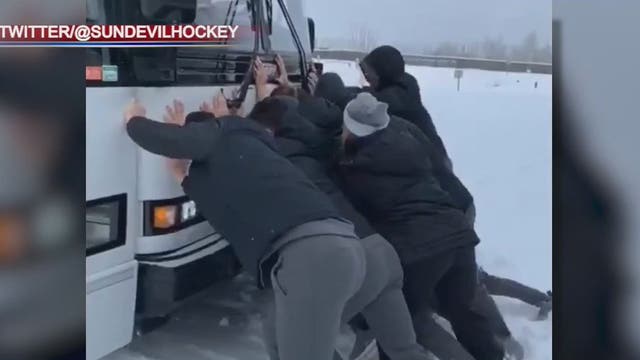 ASU hockey team pushes stuck bus out of snow in Alaska
