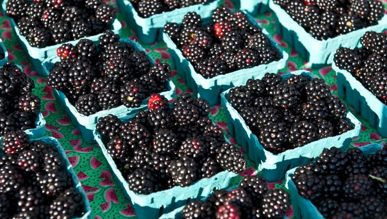 Blackberry quart containers on display at a farmers market.