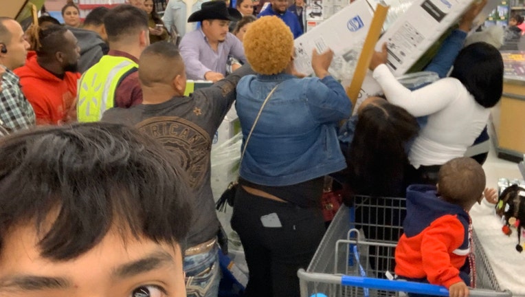 A Wal-Mart shopper takes a selfie during a Black Friday fight.