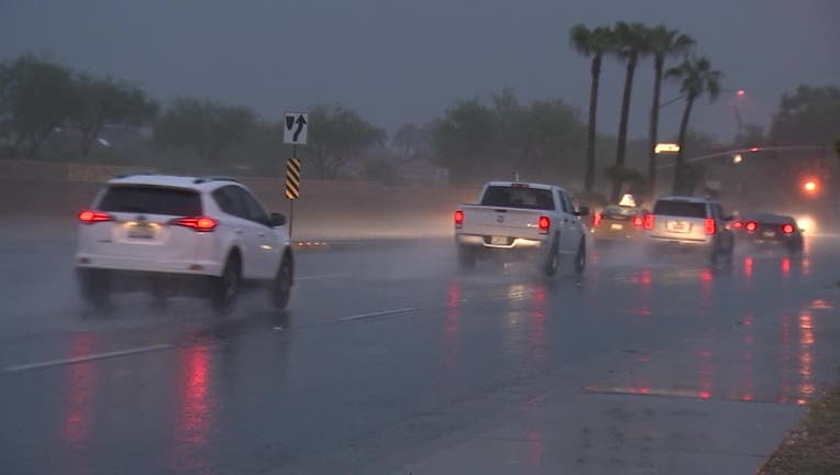 Screenshot taken from video of rain along a stretch of road in Surprise, Arizona. Cars are driving on the wet road