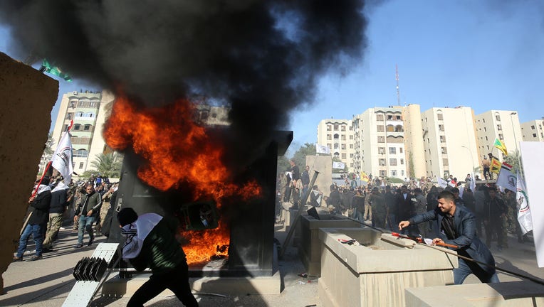 Iraqi protesters set ablaze a sentry box in front of the US embassy building in the capital Baghdad to protest against the weekend's air strikes by US planes on several bases belonging to the Hezbollah brigades near Al-Qaim, an Iraqi district bordering Syria, on December 31, 2019. (Photo by Ahmad AL-RUBAYE / AFP) (Photo by AHMAD AL-RUBAYE/AFP via Getty Images)