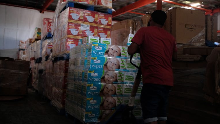 A man removes diapers and baby wipes from a warehouse filled with supplies, believed to have been from when Hurricane Maria struck the island in 2017, in Ponce, Puerto Rico on Jan. 18, 2020. (Photo by RICARDO ARDUENGO/AFP via Getty Images)