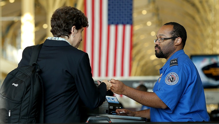 A TSA officer checks travel documents for passengers traveling through Reagan National Airport in Arlington, Virginia. Starting October 1, 2020, passengers will need REAL ID-compliant identification for air travel.