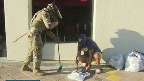 Members of the National Guard help community members clean up Long Beach following night of unrest