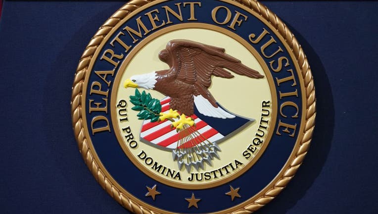 FILE - The Department of Justice seal is seen on a lectern ahead of a press conference announcing efforts against computer hacking and extortion at the Department of Justice in Washington, DC on November 28, 2018. 
