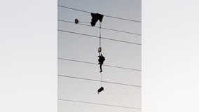Paratrooper entangled in high-voltage power lines, requiring rescue