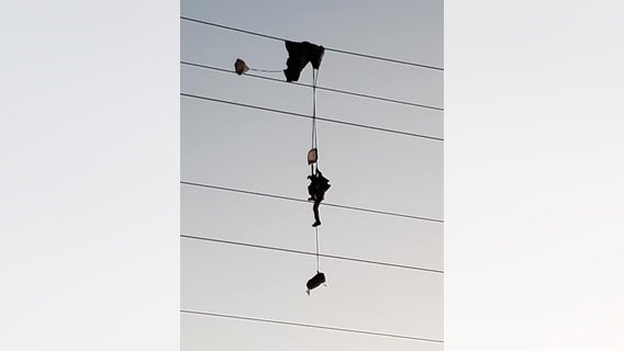 Paratrooper entangled in high-voltage power lines, requiring rescue