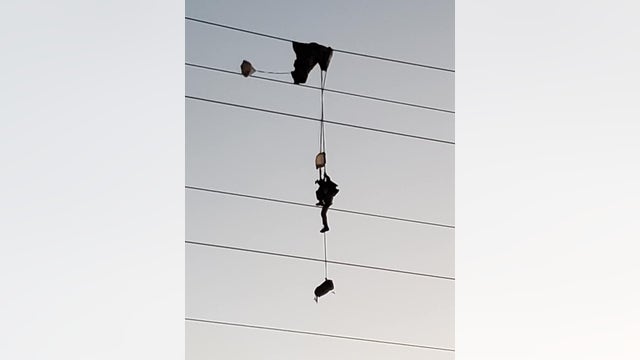 Paratrooper entangled in high-voltage power lines, requiring rescue