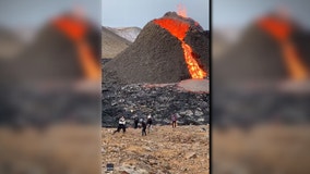 People play volleyball in front of erupting volcano in Iceland