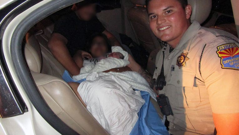 DPS trooper smiles with mother and baby