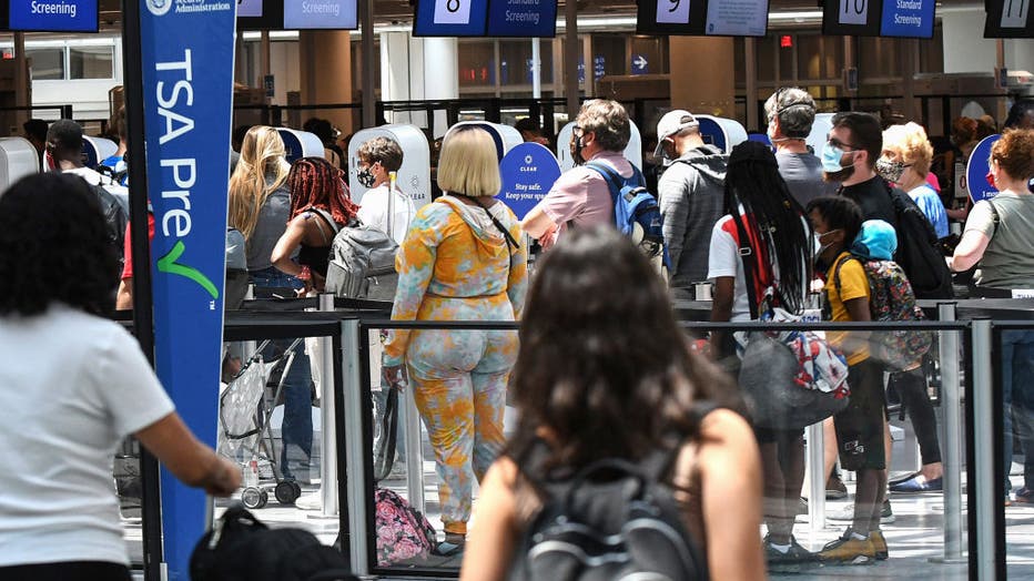 Travelers wait in line at a Transportation Security