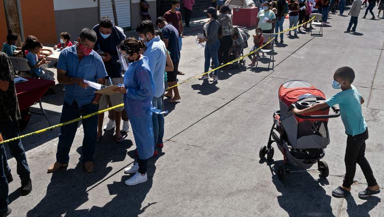 Asylum seekers camping at El Chaparral crossing port queue to be vaccinated against COVID-19